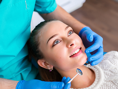 A dental professional performing a teeth cleaning procedure on a patient s mouth.